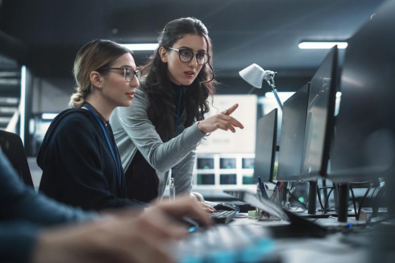 Mujeres revisando un tema en un computador